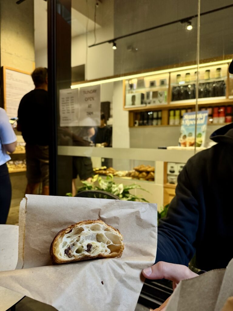 man showing the inside of a chocolate croissant